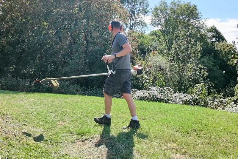 Tom strimming a grass bank